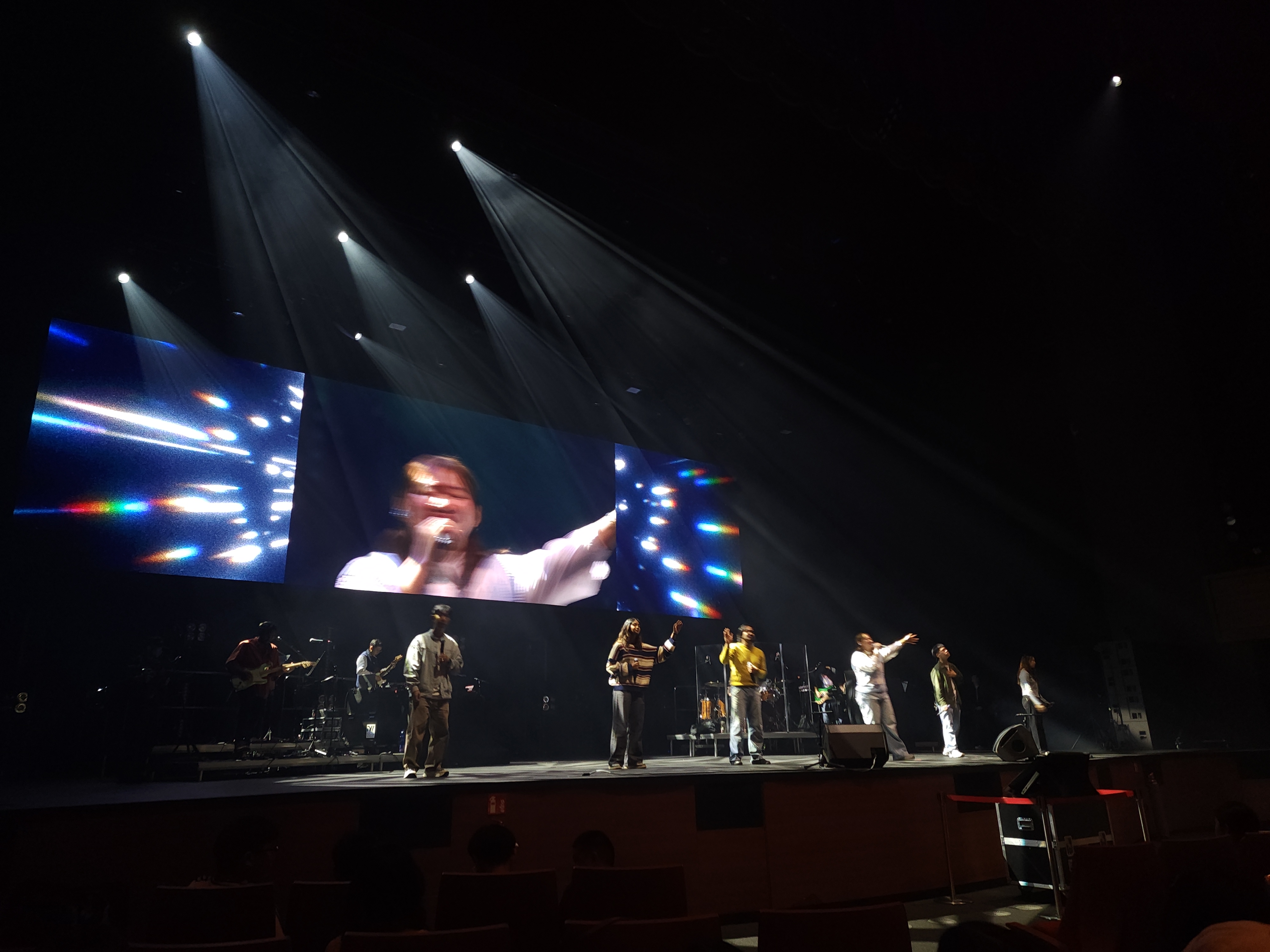 Concert spotlights casting long beams over a stage